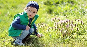 toddler playing in grass_kids potential language therapy_352x190